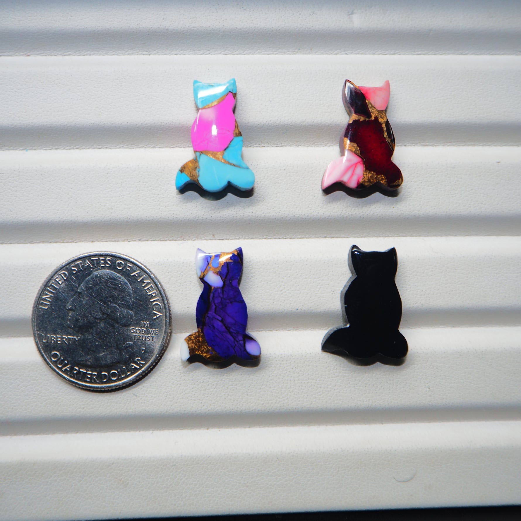 Cat shape cabochon collection 4 colour variants display Pedra Gems quarter dollar size reference