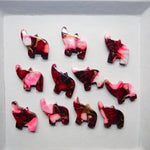 Set of red and pink animal-shaped jewelry pieces on a white background