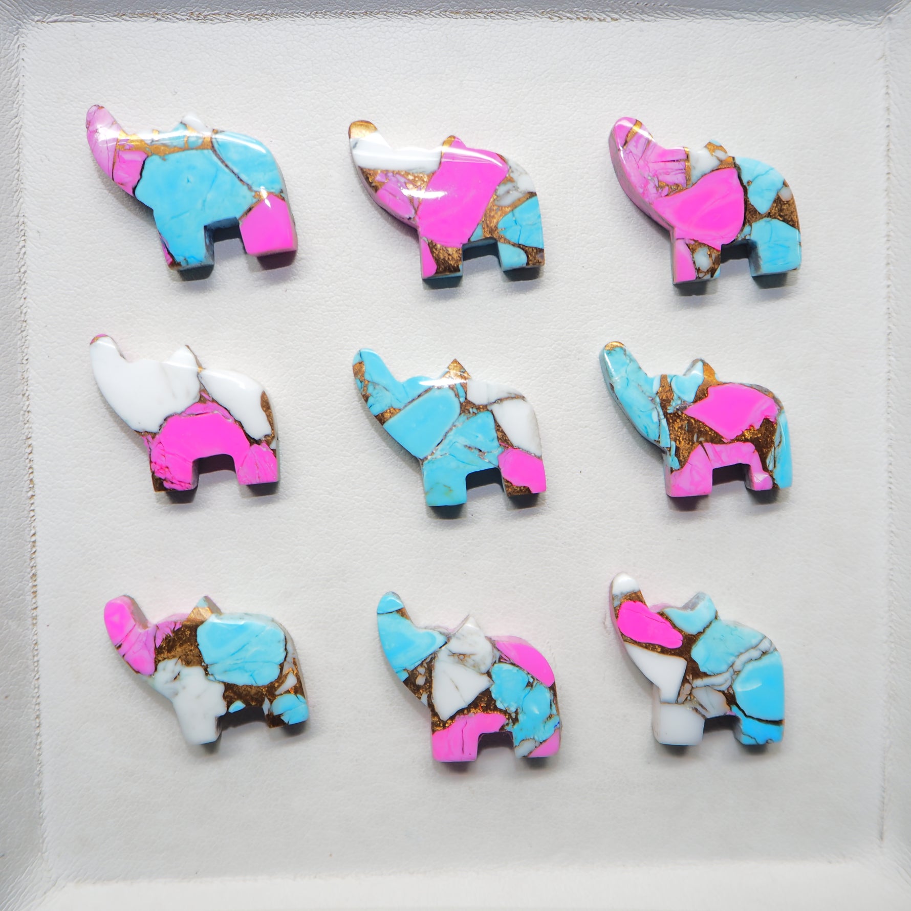 Set of colorful elephant-shaped cookies on a white surface