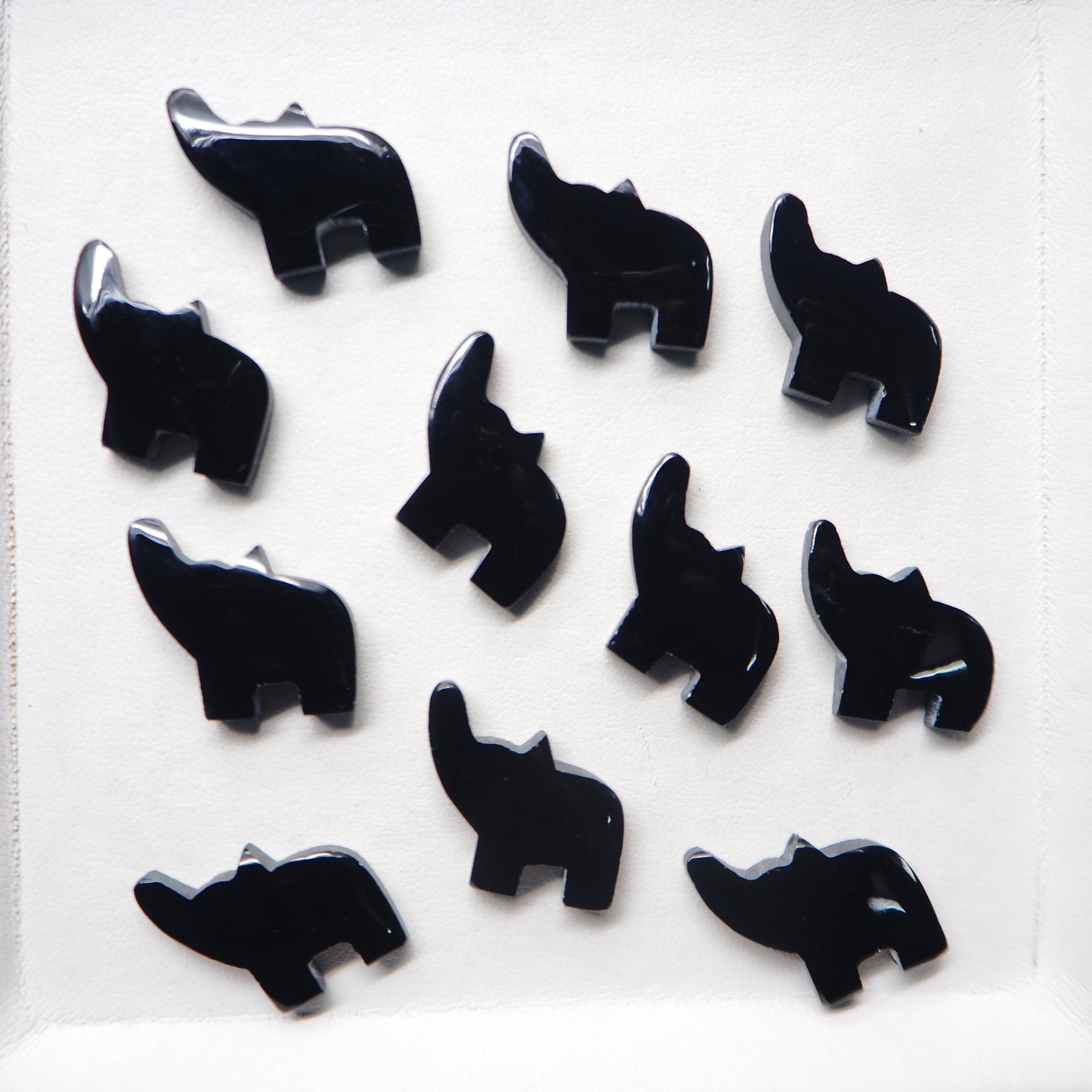 Black elephant-shaped objects on a white background